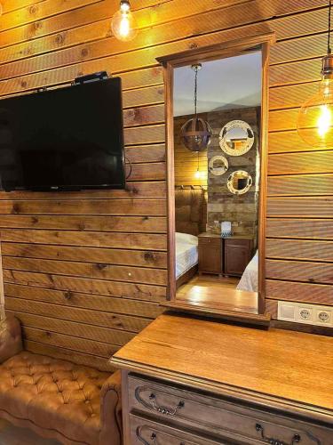 a bedroom with a mirror and a television in a room at Villa Adis with Hot Pool & Jacuzzi by BookVillaBG in Borovets