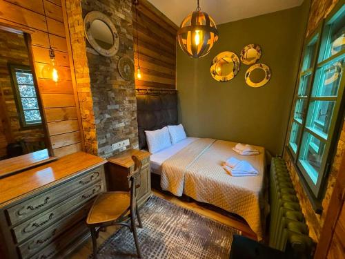 a small bedroom with a bed and a table and chair at Villa Adis with Hot Pool & Jacuzzi by BookVillaBG in Borovets