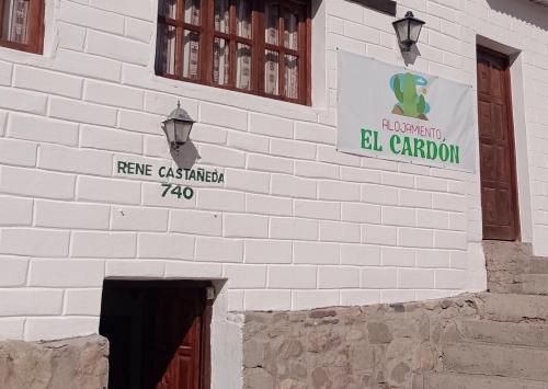 a white brick building with a sign on it at Alojamiento El Cardon Tilcara in Tilcara