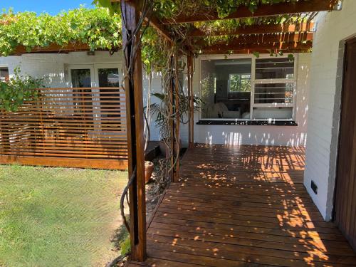 a wooden deck with a pergola on a house at Goblin's Mead in Edgemead
