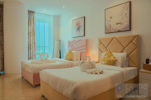a bedroom with two beds with hello kitty pillows on them at Capital Stay - 2 Bed Apartment in Dubai Festival City in Dubai