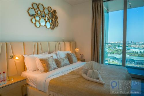 a bedroom with a large bed with a large window at Capital Stay - 2 Bed Apartment in Dubai Festival City in Dubai