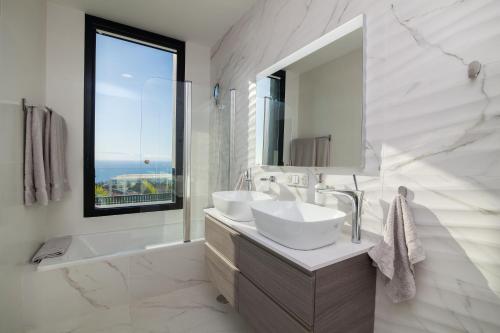 Baño blanco con 2 lavabos y espejo en 200m² NEW Villa F with private, heated pool and amazing ocean view., en Adeje