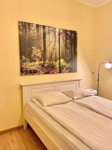 a bed in a bedroom with a painting on the wall at Kastanimaja Apartments in Tartu