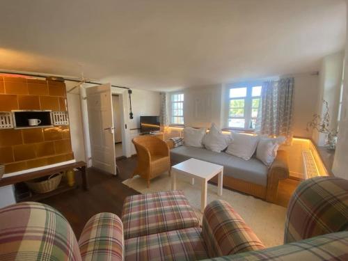 ein Wohnzimmer mit Sofa und Tisch in der Unterkunft Gemütliches Bauernhaus am Bodensee in Deggenhausertal