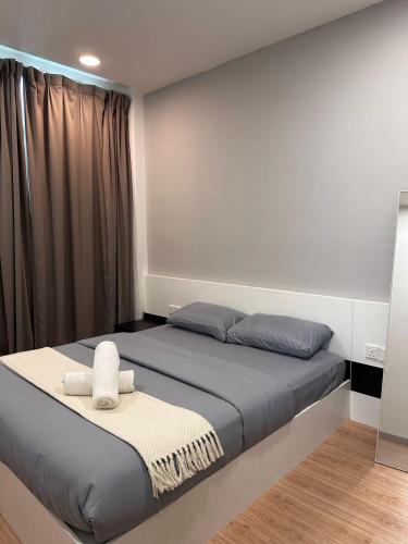 - une chambre avec un lit et 2 serviettes dans l'établissement Straits garden jelutong couple cozy georgetown, à George Town