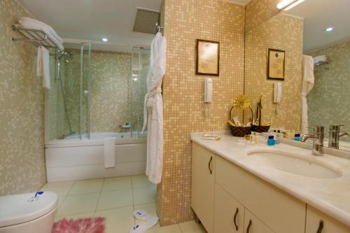 a bathroom with a tub and a sink and a toilet at Spa Hotel Colossae Thermal in Pamukkale