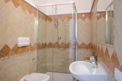 a bathroom with a shower and a toilet and a sink at Nautika Suites in Alghero