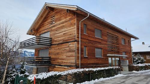 a large wooden house with snow on it at Appartement meublé à louer à Nax in Nax