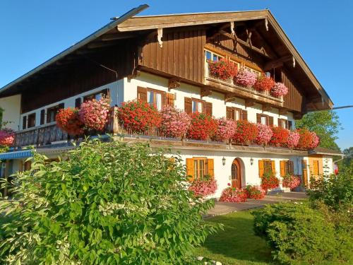 un edificio con muchas cajas de flores en él en Ferienwohnung Oberlinner, en Miesbach