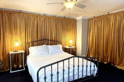 1 dormitorio con 1 cama con cortinas y 2 lámparas en Large studio apartment steps from the US Capitol!, en Washington