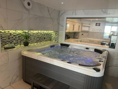 a large bath tub in a bathroom with a large window at Mara Boutique Apartments 1 in Oldbury