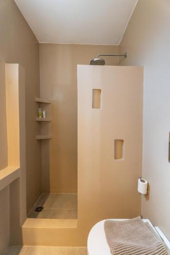 a bathroom with a white wall with a bed in it at BLUE WATERS MYKONOS in Ornos