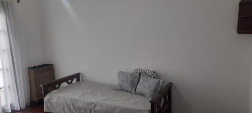 a bedroom with a bed with two pillows on it at Casa alquiler temporario Necochea in Necochea