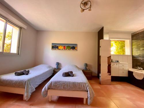 1 dormitorio con 2 camas y lavamanos en Villa entre lac et océan, en Biscarrosse