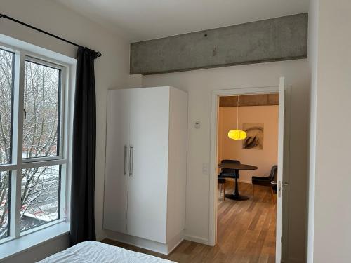 a bedroom with a white cabinet and a table at City apartment Dæmningen Vejle in Vejle
