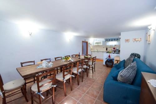 a dining room with a blue couch and a table and chairs at Casale la Rovere in Montalto di Castro