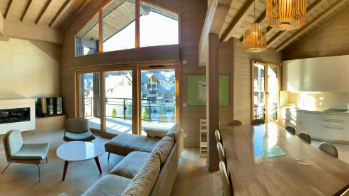 sala de estar con sofá y mesa en Le chalet sous-toiture Nánshān : spacieux, lumineux et idéalement situé à Auron, en Auron