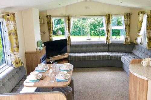 a living room with a couch and a table at Mersea Island by Away Resorts in Colchester