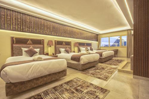ein Hotelzimmer mit 3 Betten und 2 Teppichen in der Unterkunft The Muse Pyramids Inn Hotel in Kairo