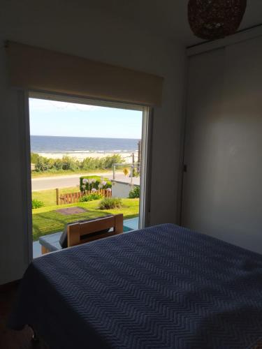 a bedroom with a bed and a view of the beach at Casas Arena y Sol - FRENTE AL MAR in Parque del Plata
