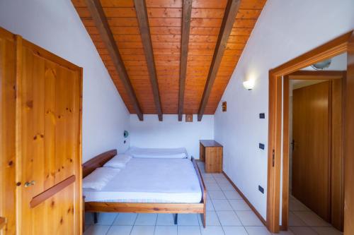 a bedroom with a bed and a wooden ceiling at Residence Stofol in Aprica