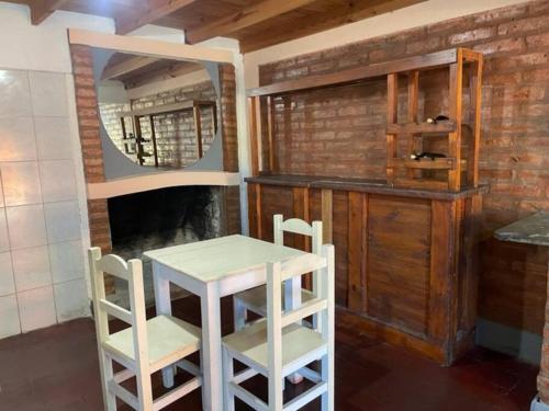 eine Küche mit einem Tisch, 2 Stühlen und einem Spiegel in der Unterkunft Duplex santa rosa in Santa Rosa del Conlara