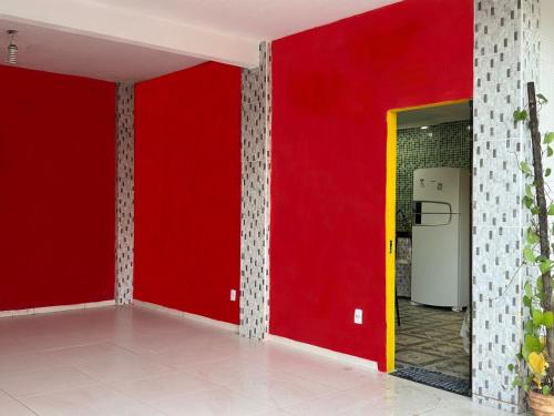 a room with a red wall and a yellow door at Recanto no jóia in Ilhéus