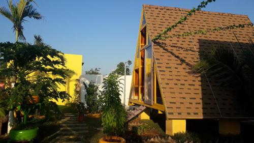 a yellow building with palm trees in front of it at Ngọc Dung Mall Homestay in Tân Phú
