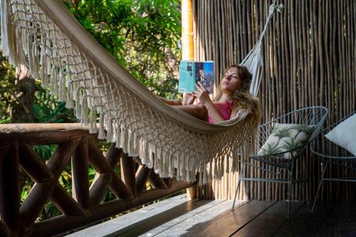 a young girl sitting in a hammock reading a book at Isla Fuerte Eco House in Isla Fuerte