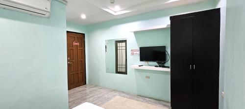 a room with a television and a room with a door at The JRJF Hotel near Tagum Terminal in Tagum