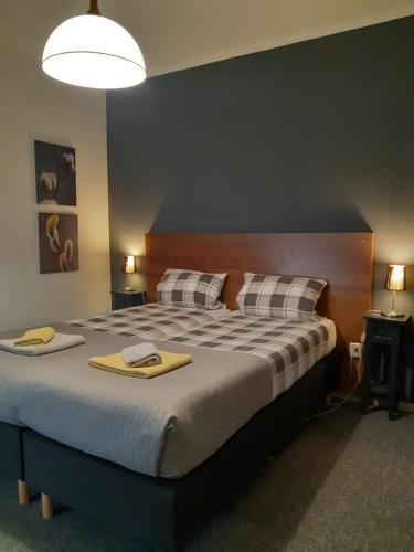 a bedroom with a large bed with two towels on it at Hoeve Heidonk in Horn