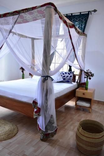 a bedroom with a bed with a mosquito net at Kili Kivuli in Msaranga