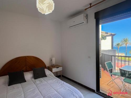 a bedroom with a bed and a view of the ocean at Estiloso Apto en P. Marítimo in Oropesa del Mar
