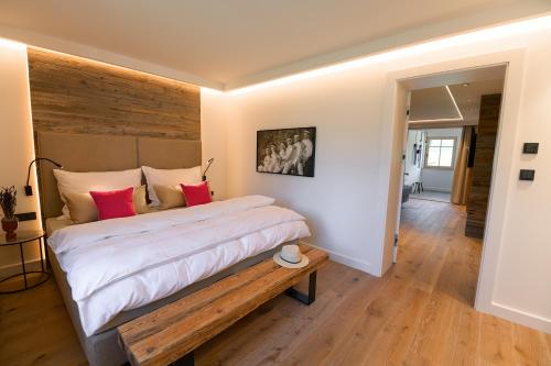 a bedroom with a large bed with a wooden headboard at DAS SALZBERG Hideaway Bad Aussee - Adults only in Bad Aussee
