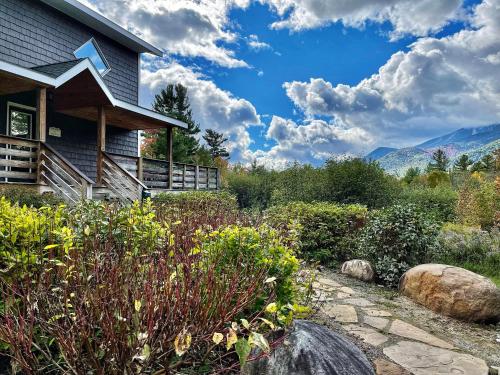 a garden in front of a house with mountains in the background at Stunning Views, Luxury, Near Whiteface,Lake Placid in Wilmington