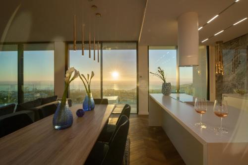 Un comedor con una mesa con copas de vino. en 200m NEW Villa E with priv/heated pool, ocean view., en Adeje