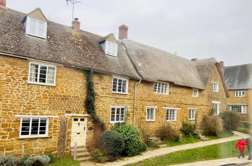 a row of brick houses with white windows at Large room in Stunning Cottage Edge of the Cotswolds in Bloxham