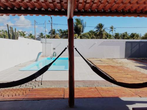 a hammock in front of a swimming pool at Casa de Praia Em Aracaju,Se in Barra dos Coqueiros