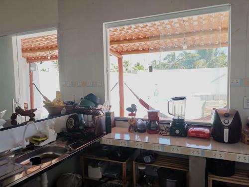 a kitchen with a counter top with a window at Casa de Praia Em Aracaju,Se in Barra dos Coqueiros
