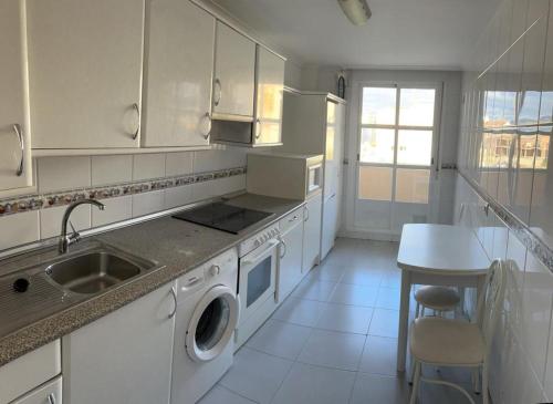 - une cuisine blanche avec un évier et un lave-linge dans l'établissement Apartamento Magdalena, à Haro
