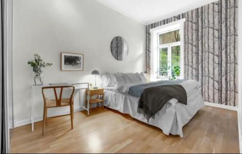 1 dormitorio con cama, escritorio y ventana en Alexander Kiellands plass - City Center Oslo en Oslo