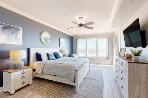 a bedroom with blue walls and a bed with a television at Belmont Towers in Ocean City