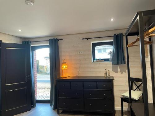um quarto com uma cómoda e uma cama com uma janela em Ambiance boisée Moustier em Stoumont