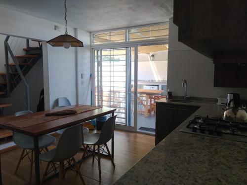 a kitchen with a table and chairs and a dining room at Casas Arena y Sol - FRENTE AL MAR in Parque del Plata