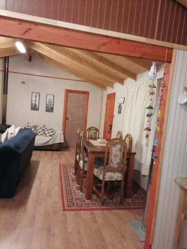 uma sala de estar com uma mesa e cadeiras e uma cama em Piso acogedor y familiar en el campo em Villarrica