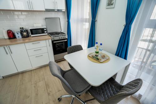 a small kitchen with a white table and chairs at Modern & Comfortable Apartament Cismigiu Park - POP3 in Bucharest