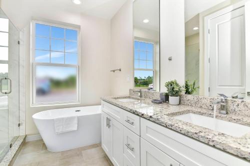 y baño blanco con bañera, lavamanos y bañera. en Beautiful 5 bed home Resort 5 minutes from Disney, en Orlando