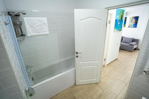 a bathroom with a shower and a glass door at Modern & Comfortable Apartament Cismigiu Park - POP3 in Bucharest