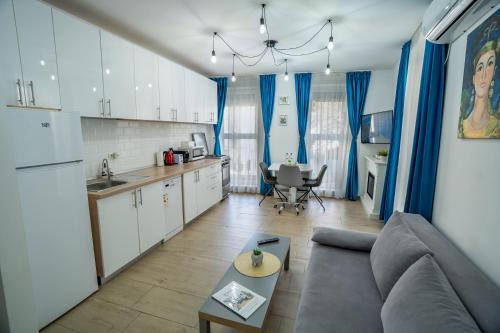 een woonkamer met een bank en een keuken bij Modern & Comfortable Apartament Cismigiu Park - POP3 in Boekarest